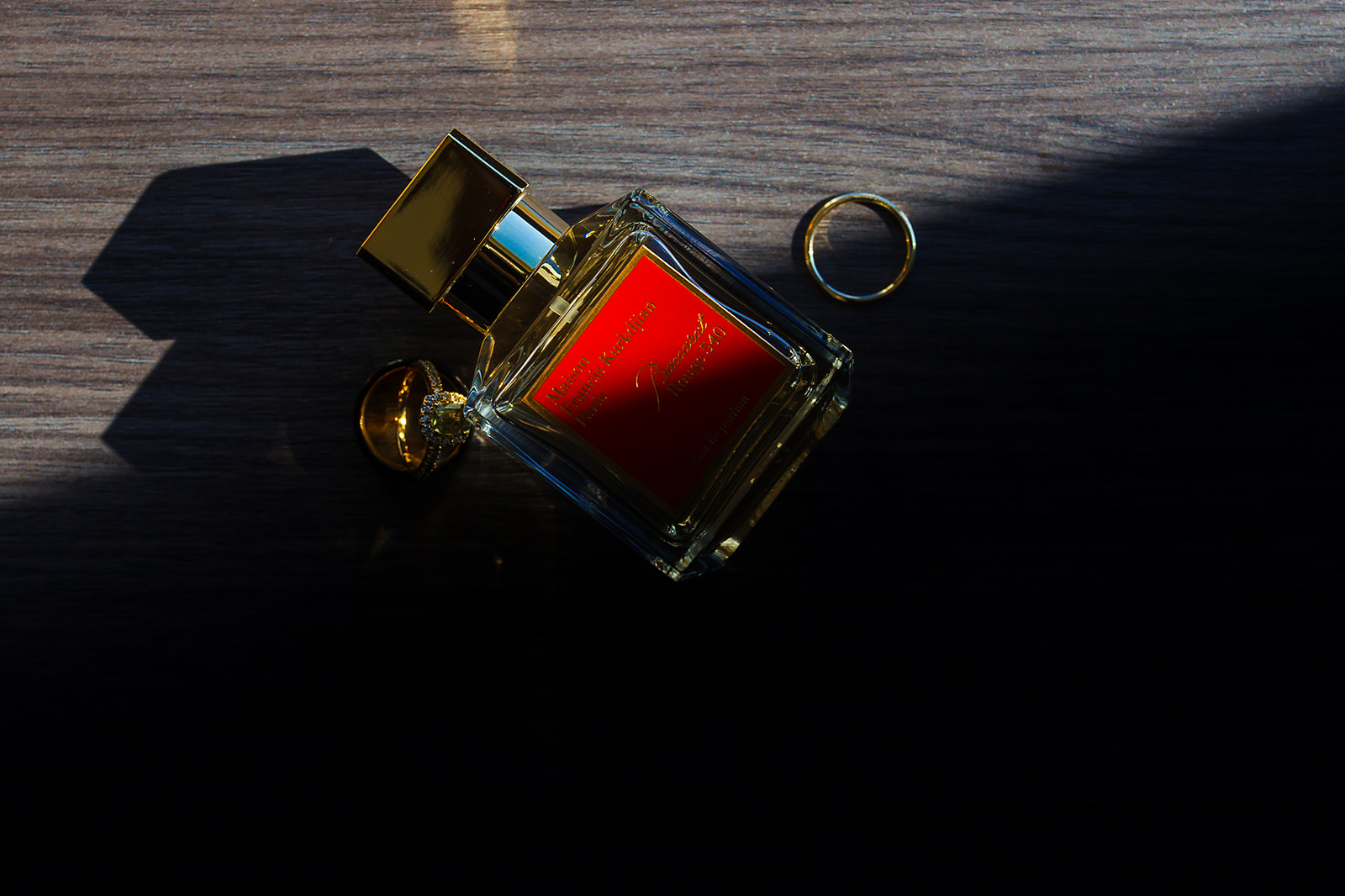 Baccarat Rouge perfume with rings in dramatic shadow
