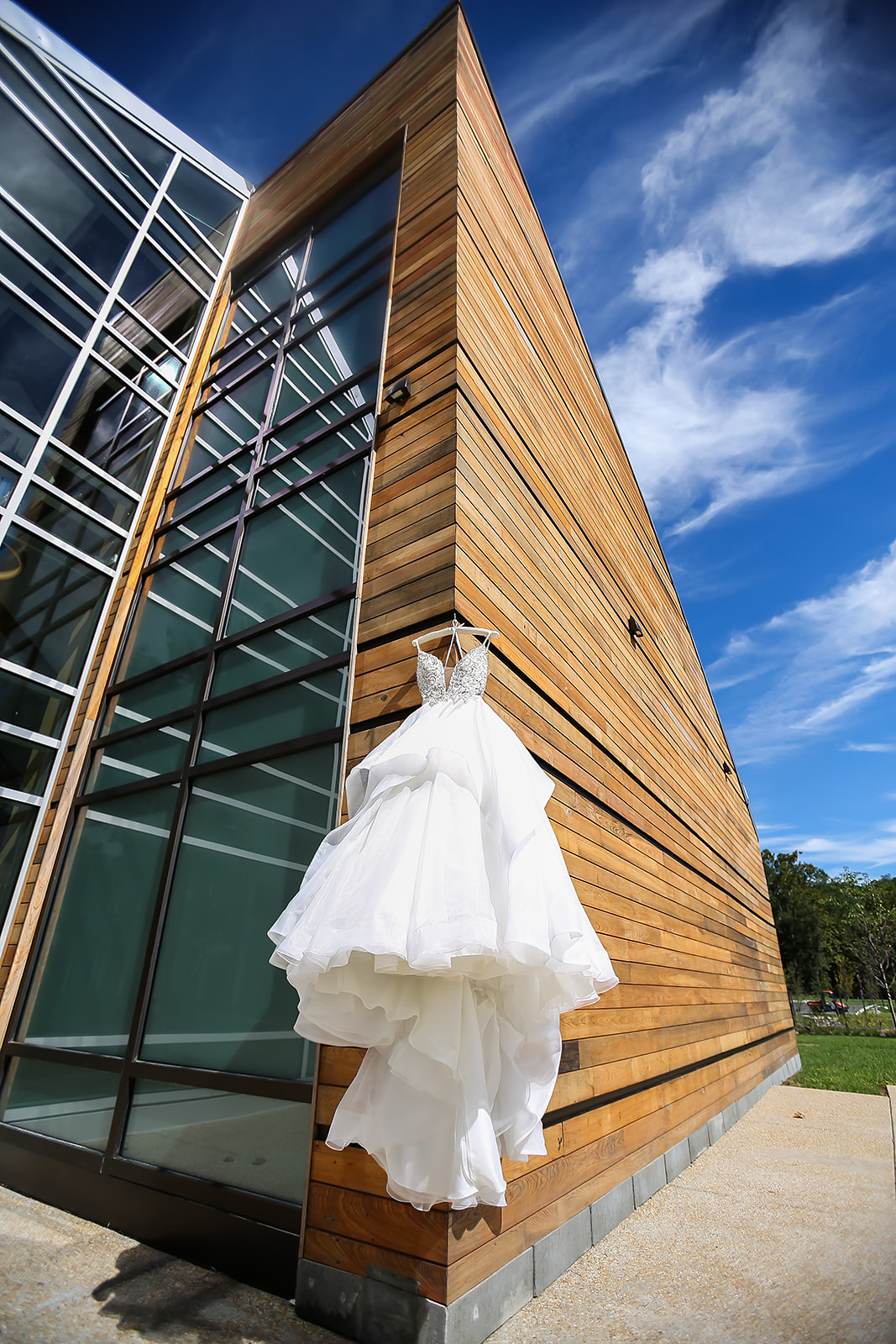 Ballgown dress hanging on modern architecture blue sky