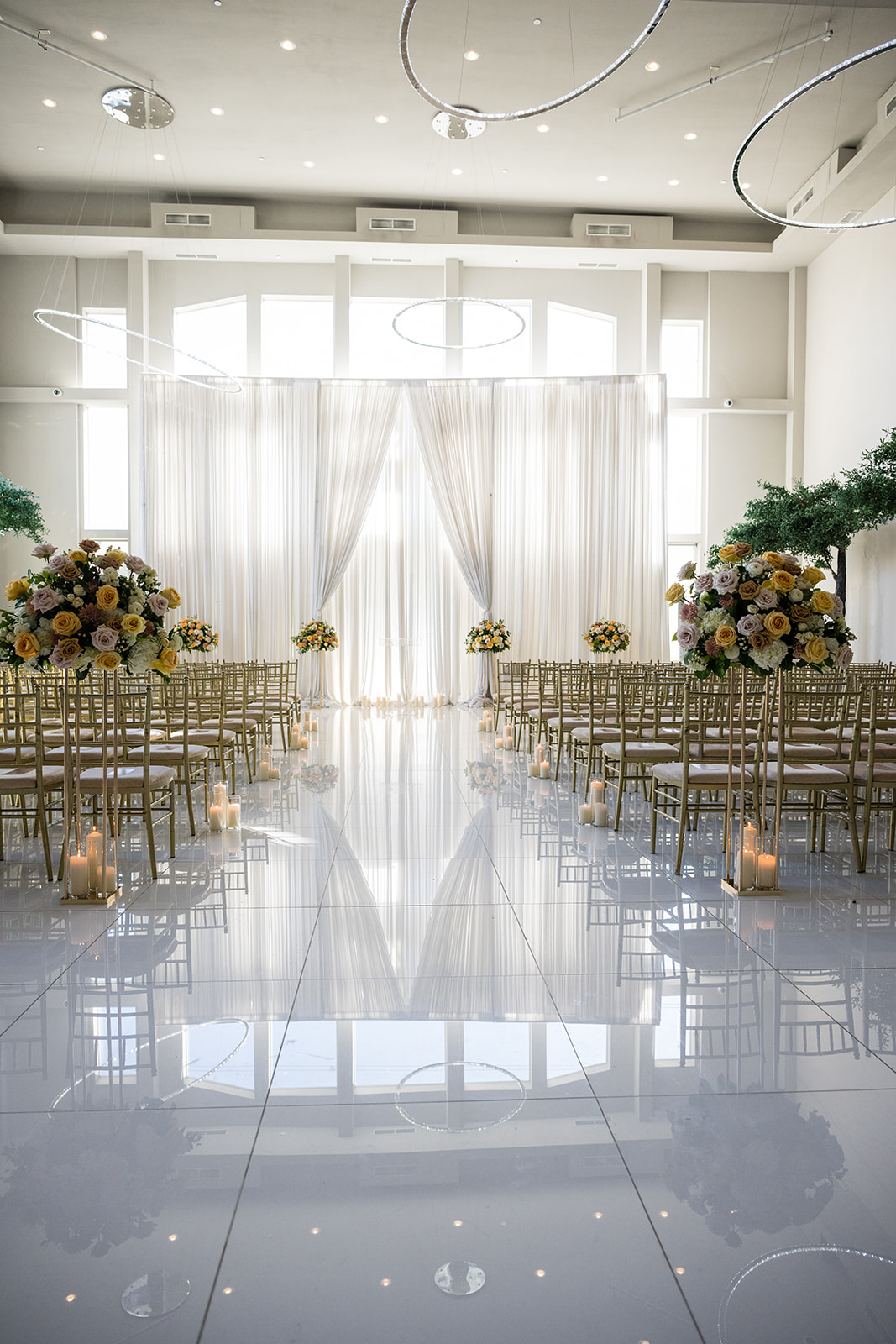Ceremony aisle with florals candles and gold chairs