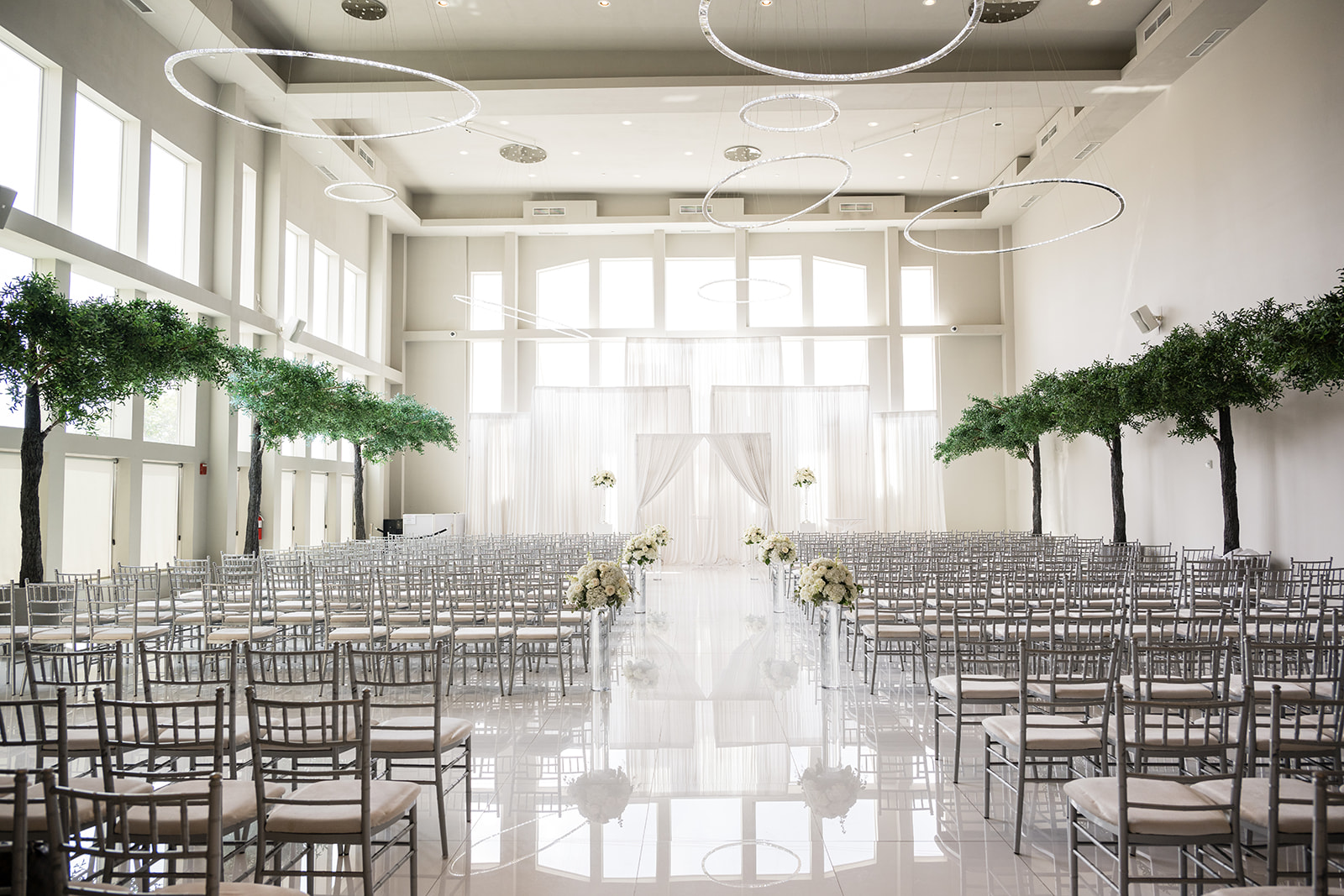 Ceremony venue with white chiavari chairs and draping