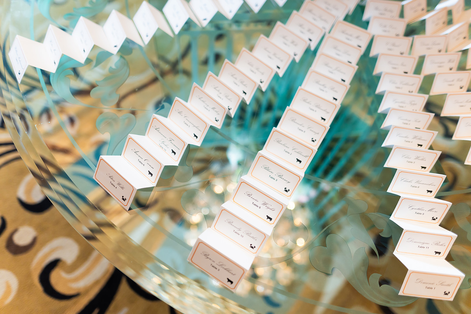 Escort cards with calligraphy on glass table display