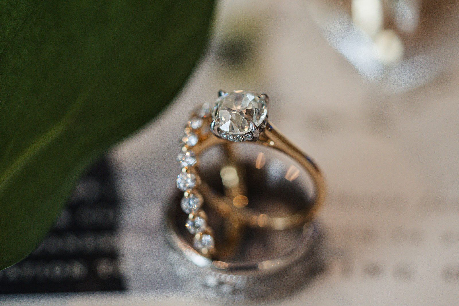 Gold solitaire ring with greenery leaf macro