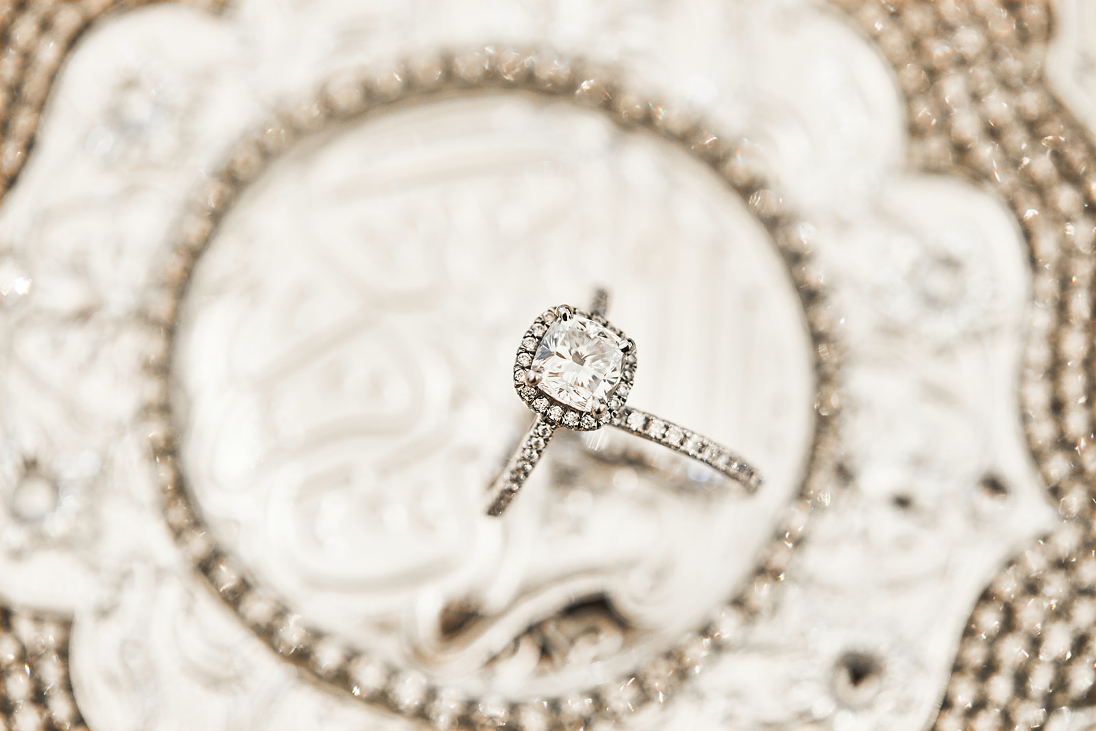 Halo ring on ornate silver plate macro