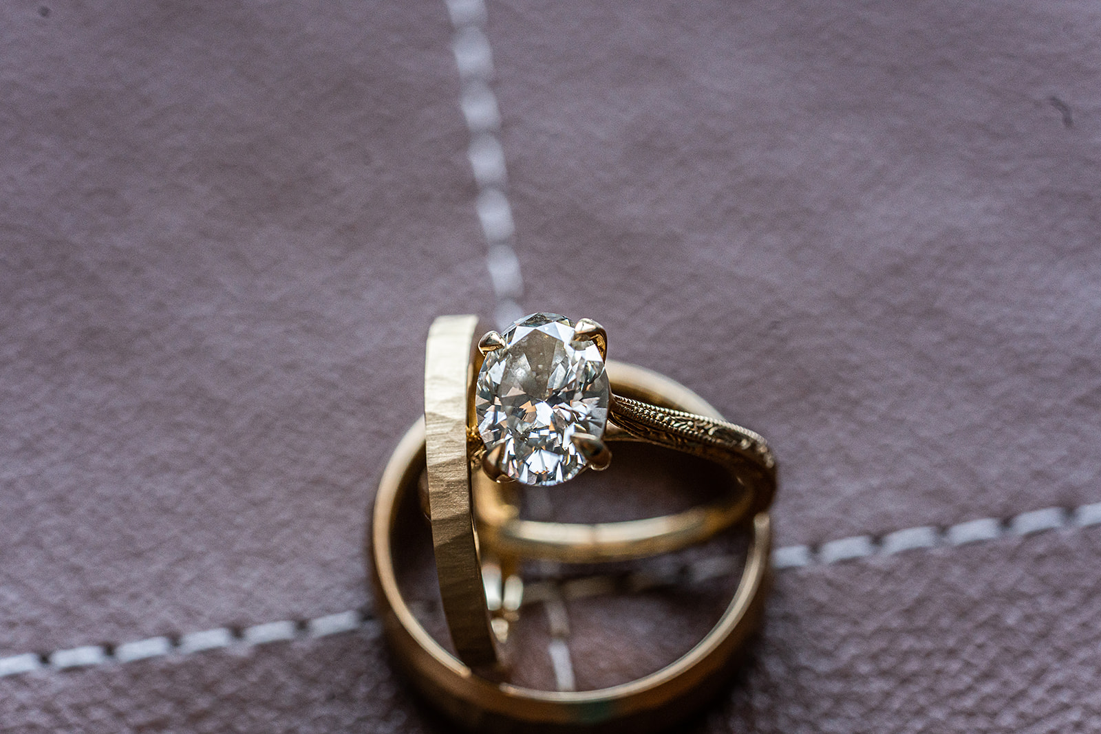 Oval gold rings on leather stitching macro