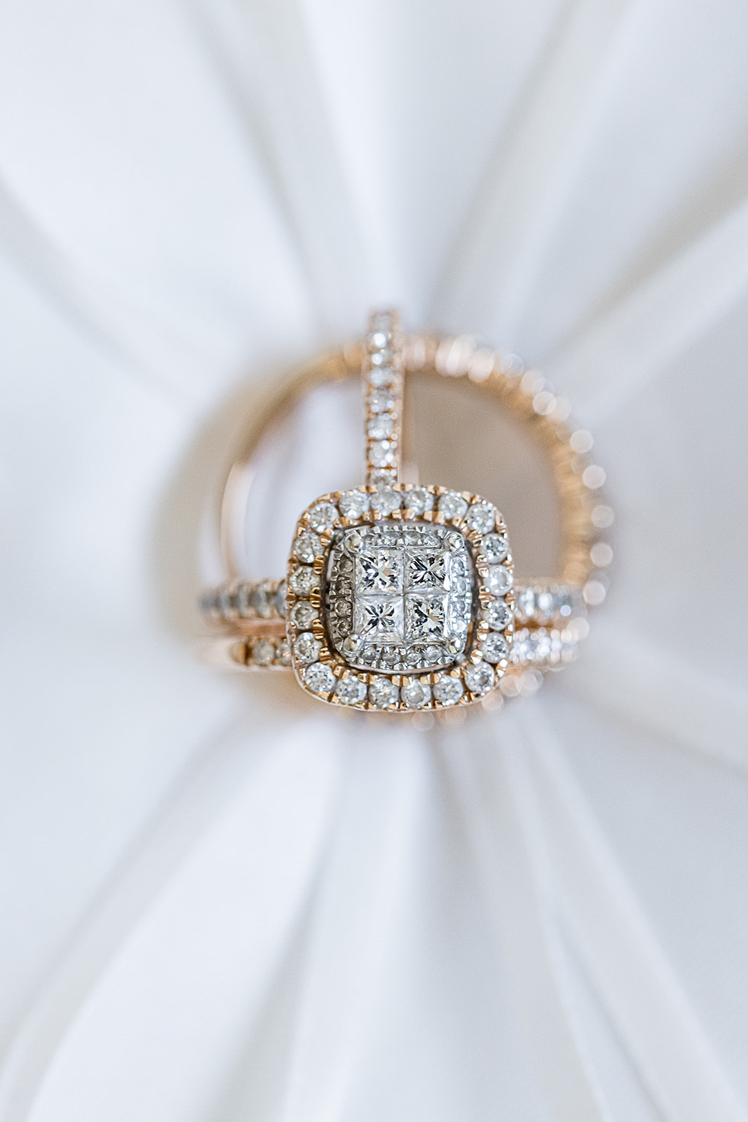 Rose gold double halo ring on satin fabric