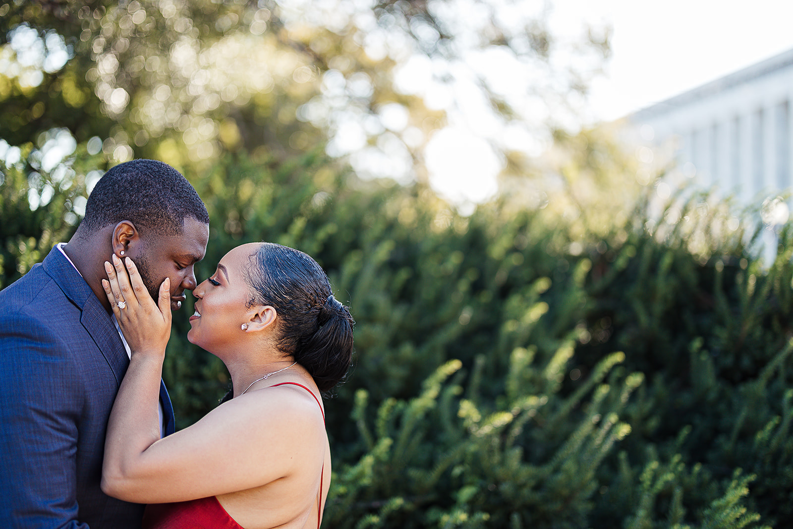 Couple kiss in garden greenery at golden hour