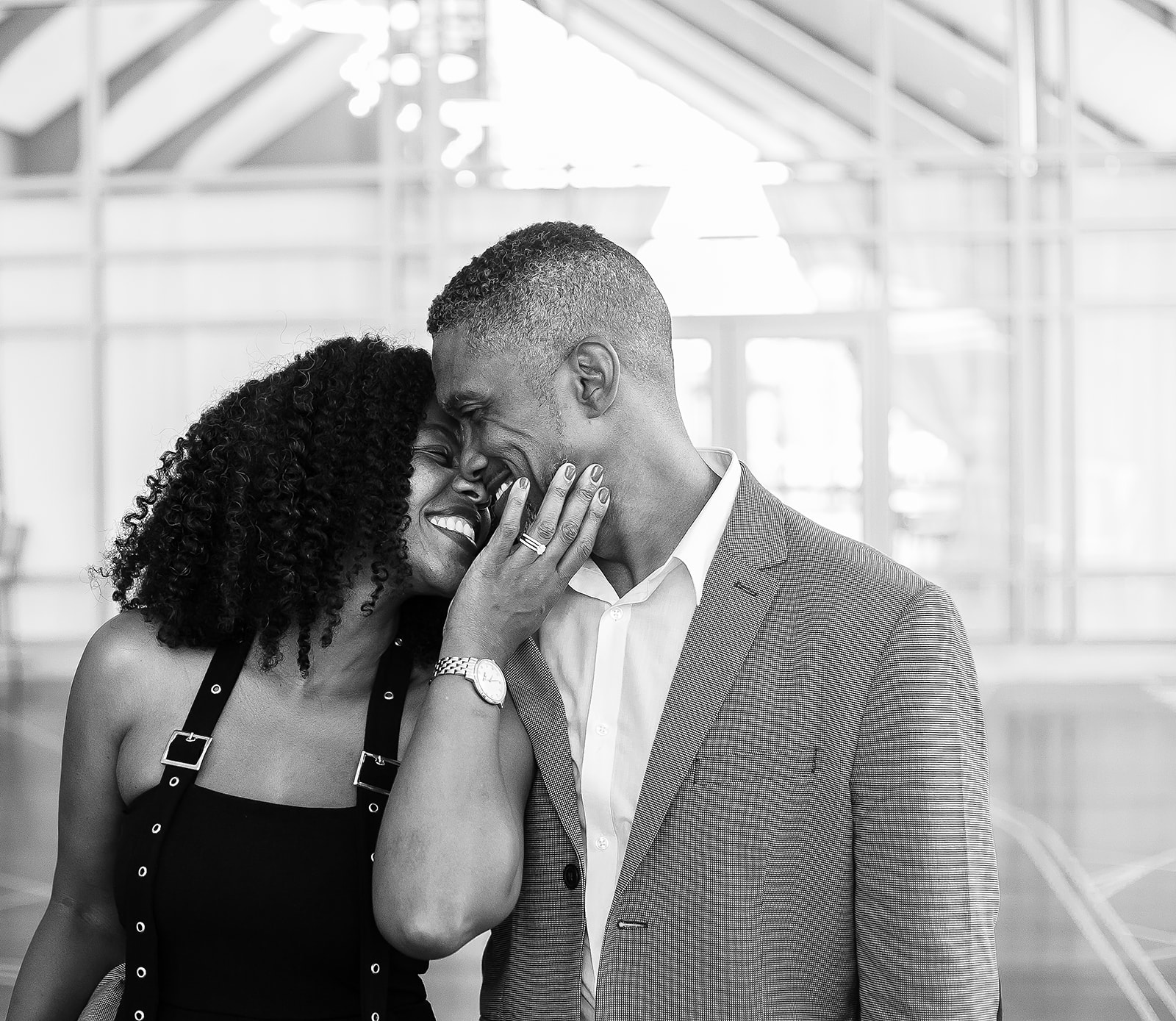 Couple laughing closeup in glass atrium black and white intimate