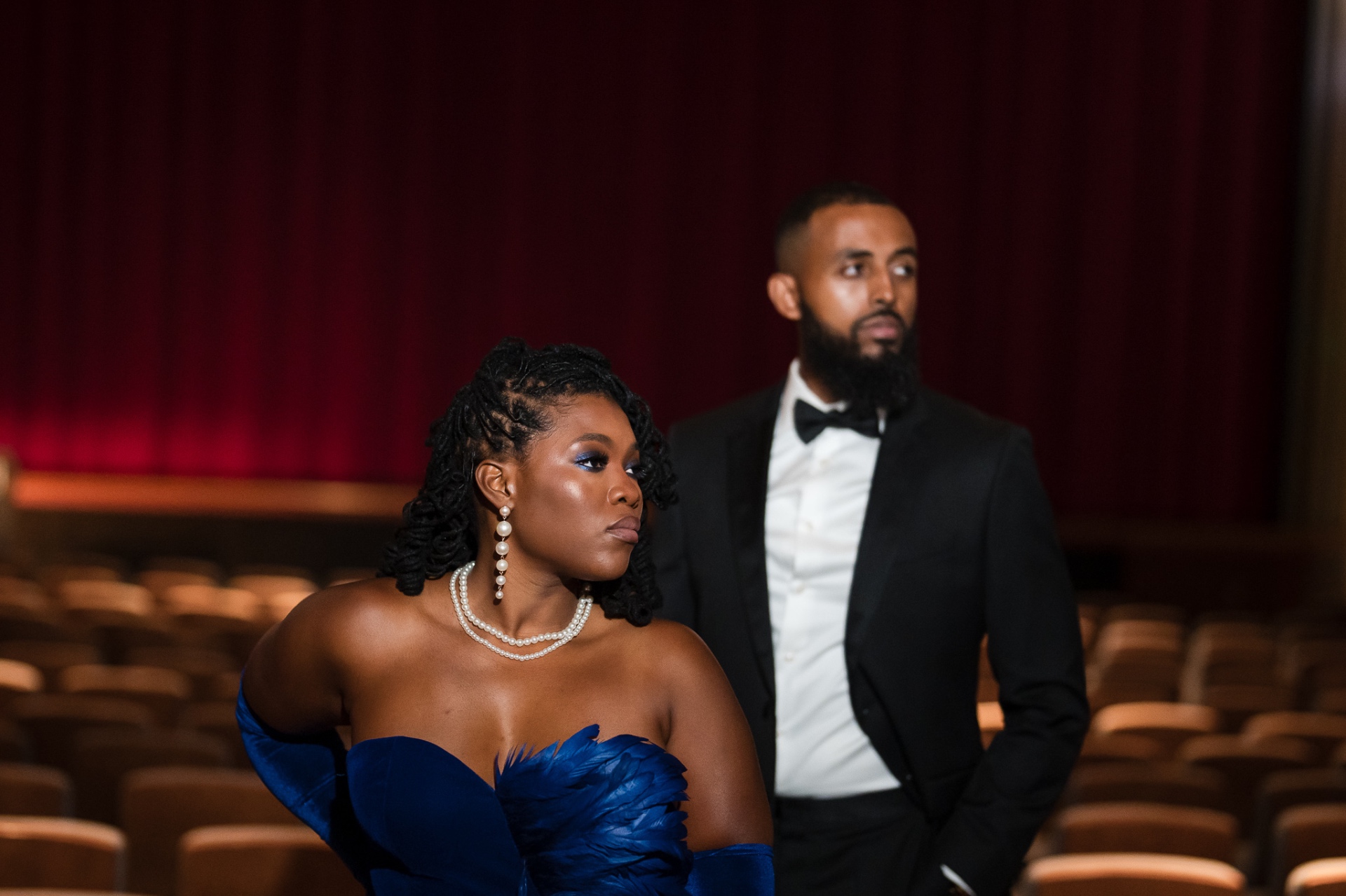 Couple in theater blue feather gown pearls tuxedo editorial