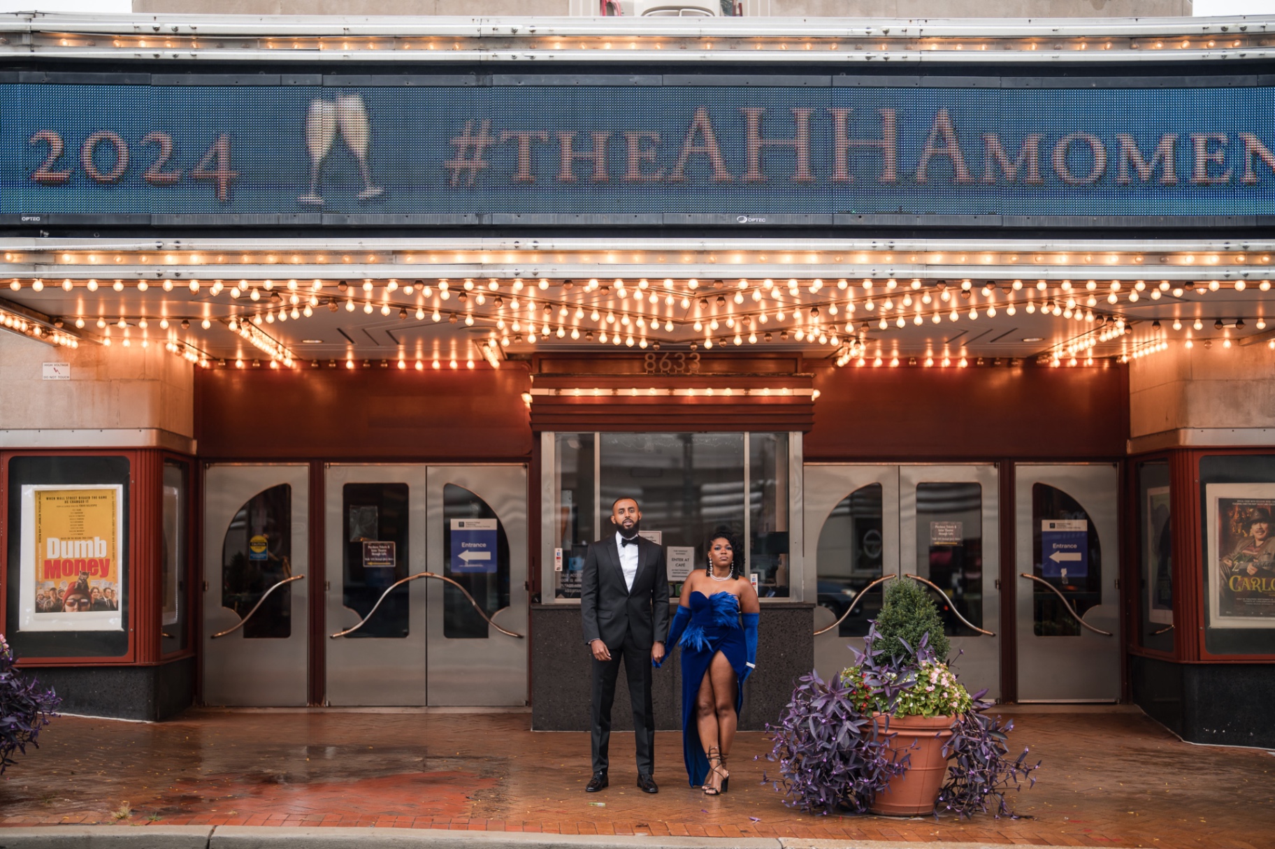 Couple at theater marquee with lights formal