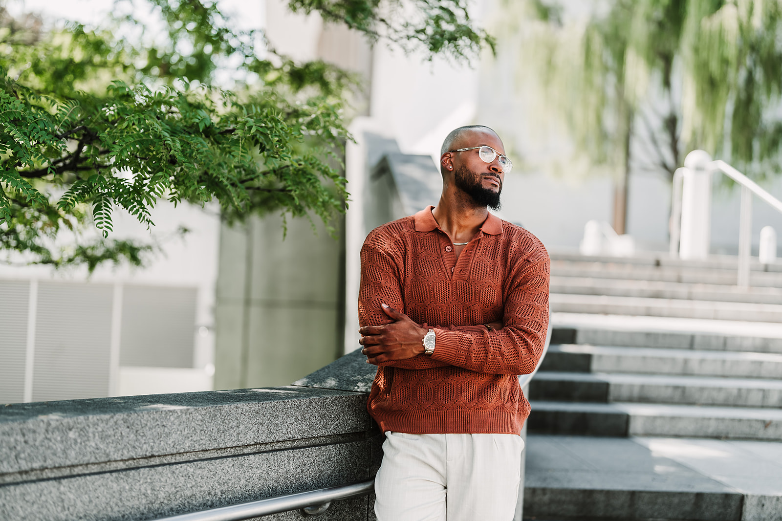 Man in rust sweater on urban steps portrait