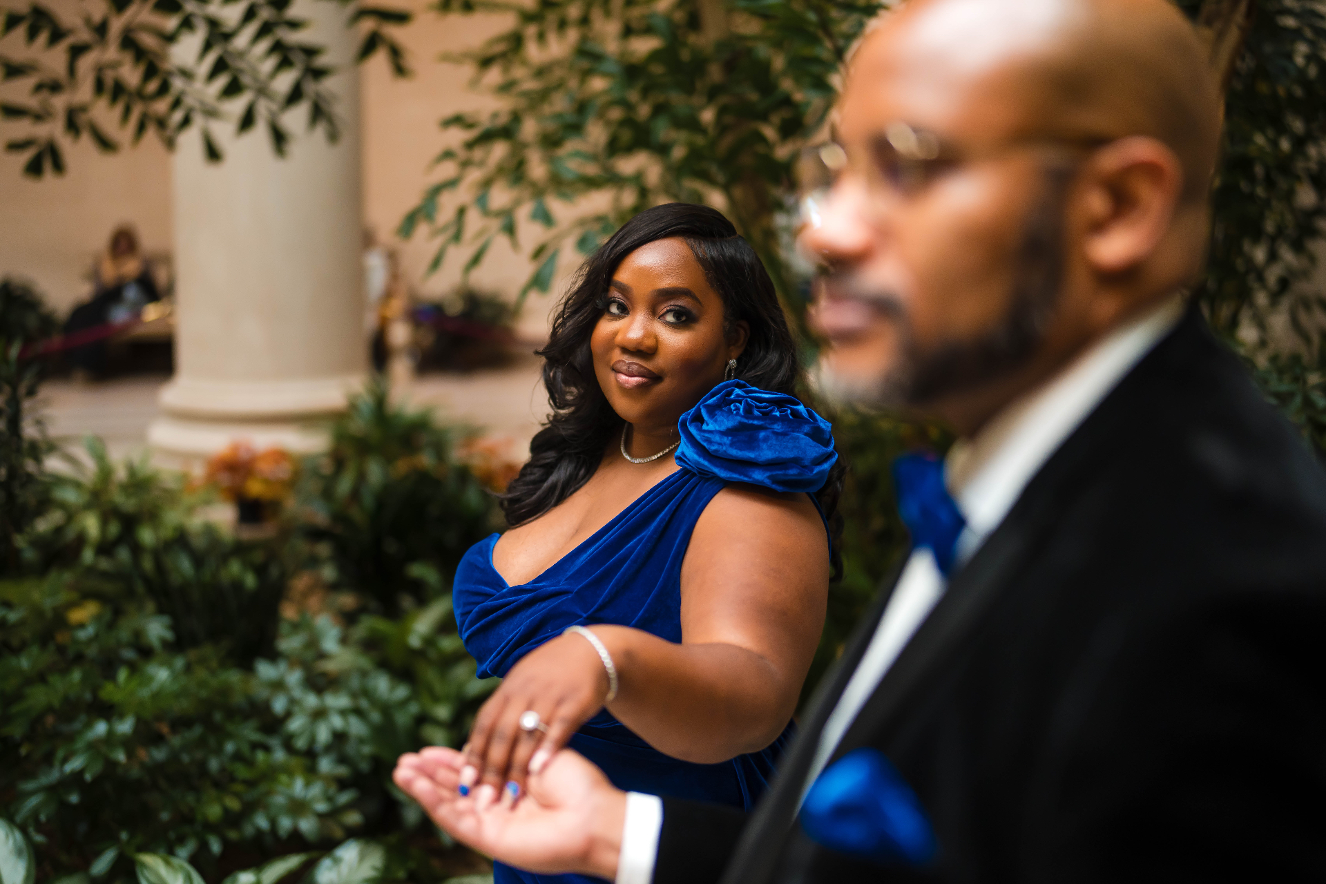 Woman glancing in conservatory blue gown with bokeh