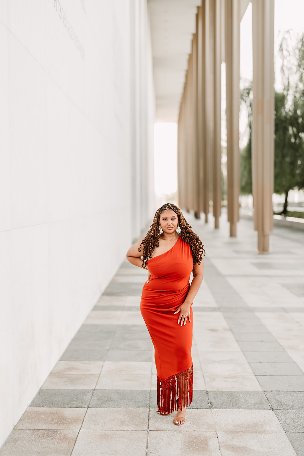 Woman in red dress by memorial columns portrait