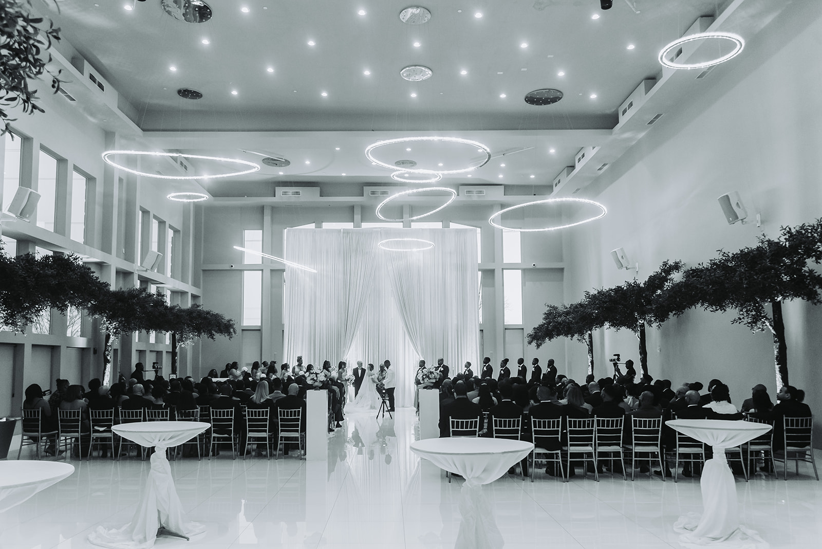 Modern ceremony venue with ring lights and draping black and white wide shot