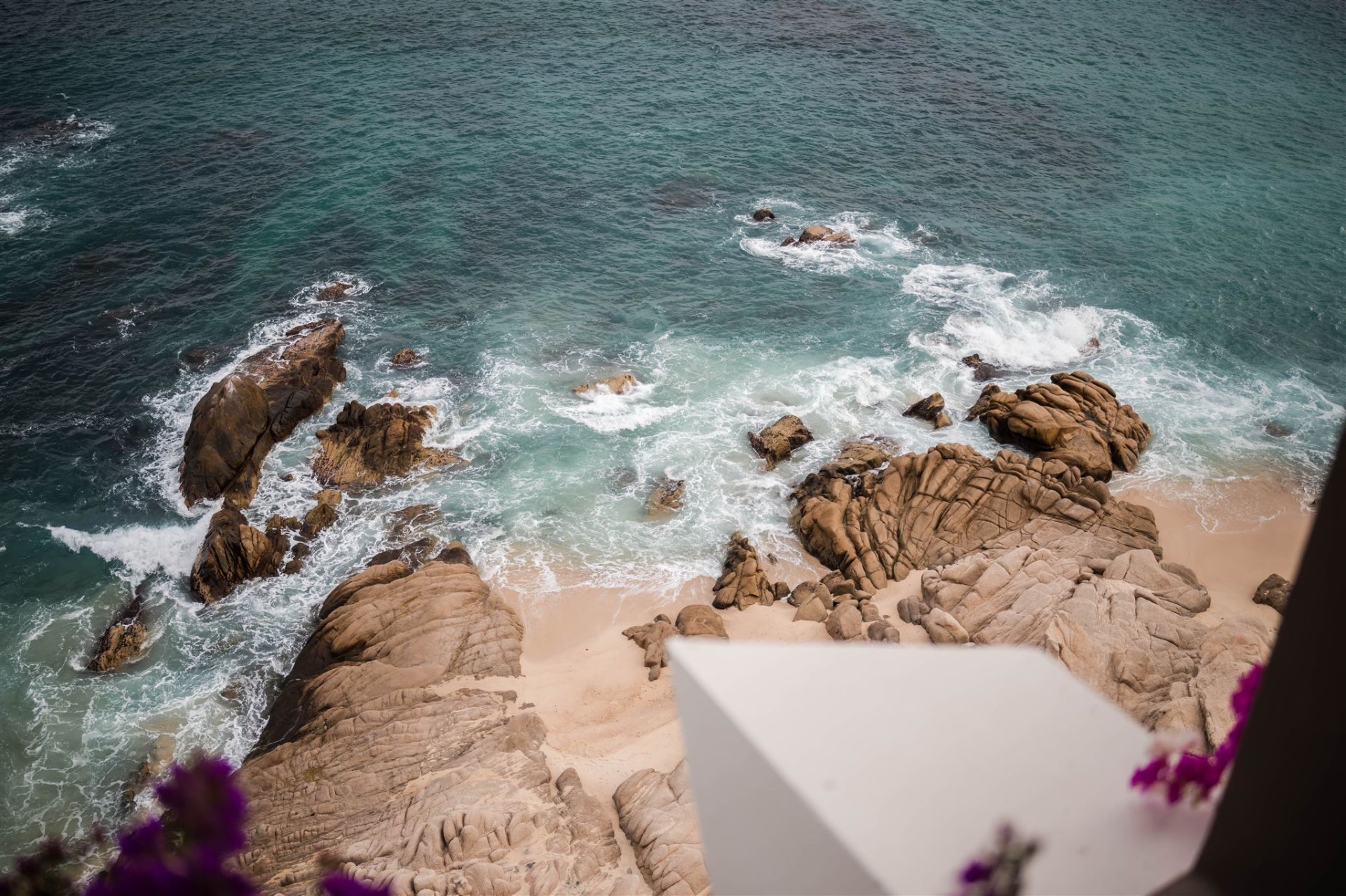 Turquoise ocean waves crashing on rocks sandy beach Los Cabos destination