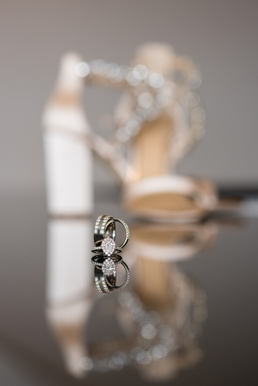 Oval halo engagement ring and band with bridal heels bokeh reflection