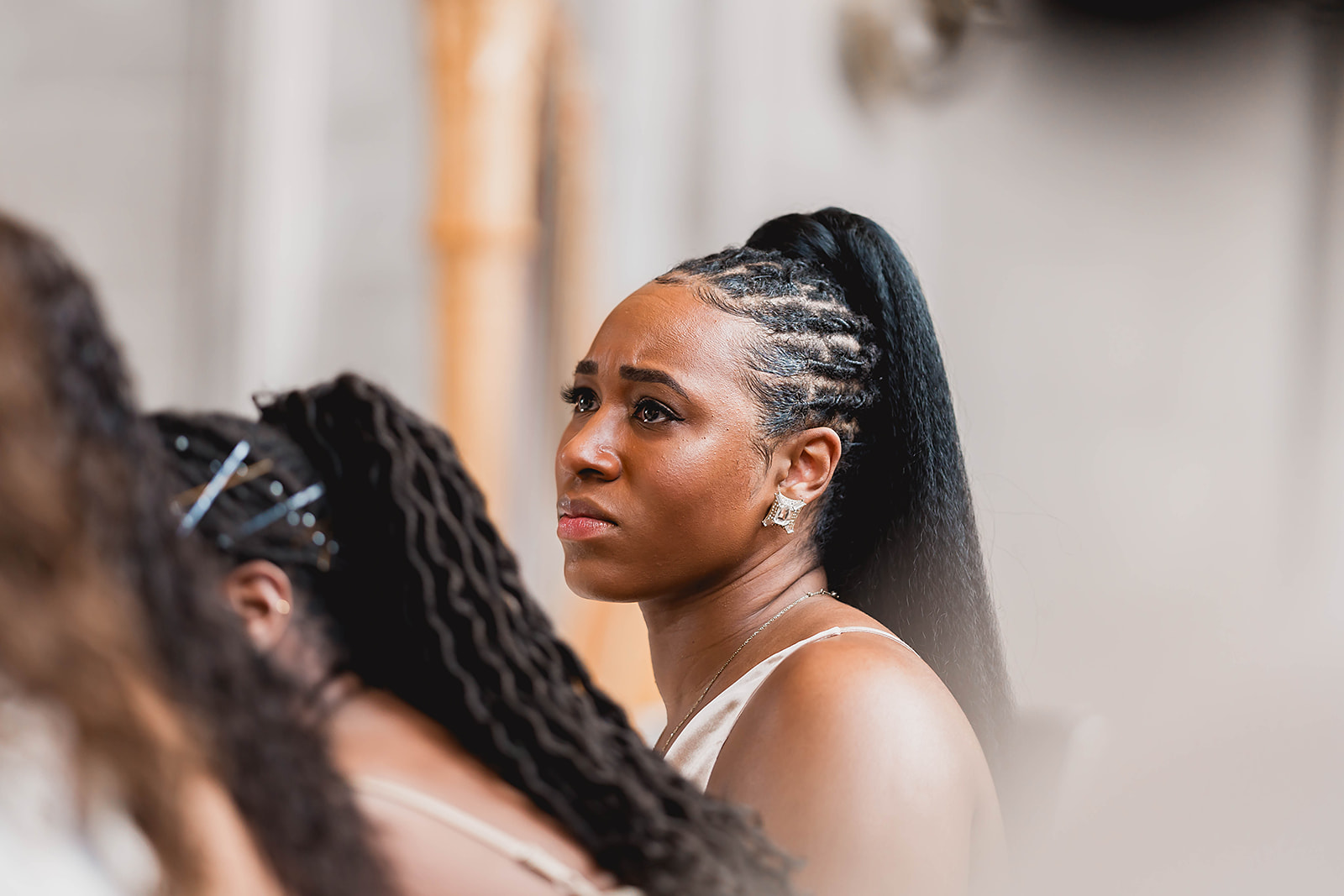 Wedding guest emotional with braids profile during ceremony