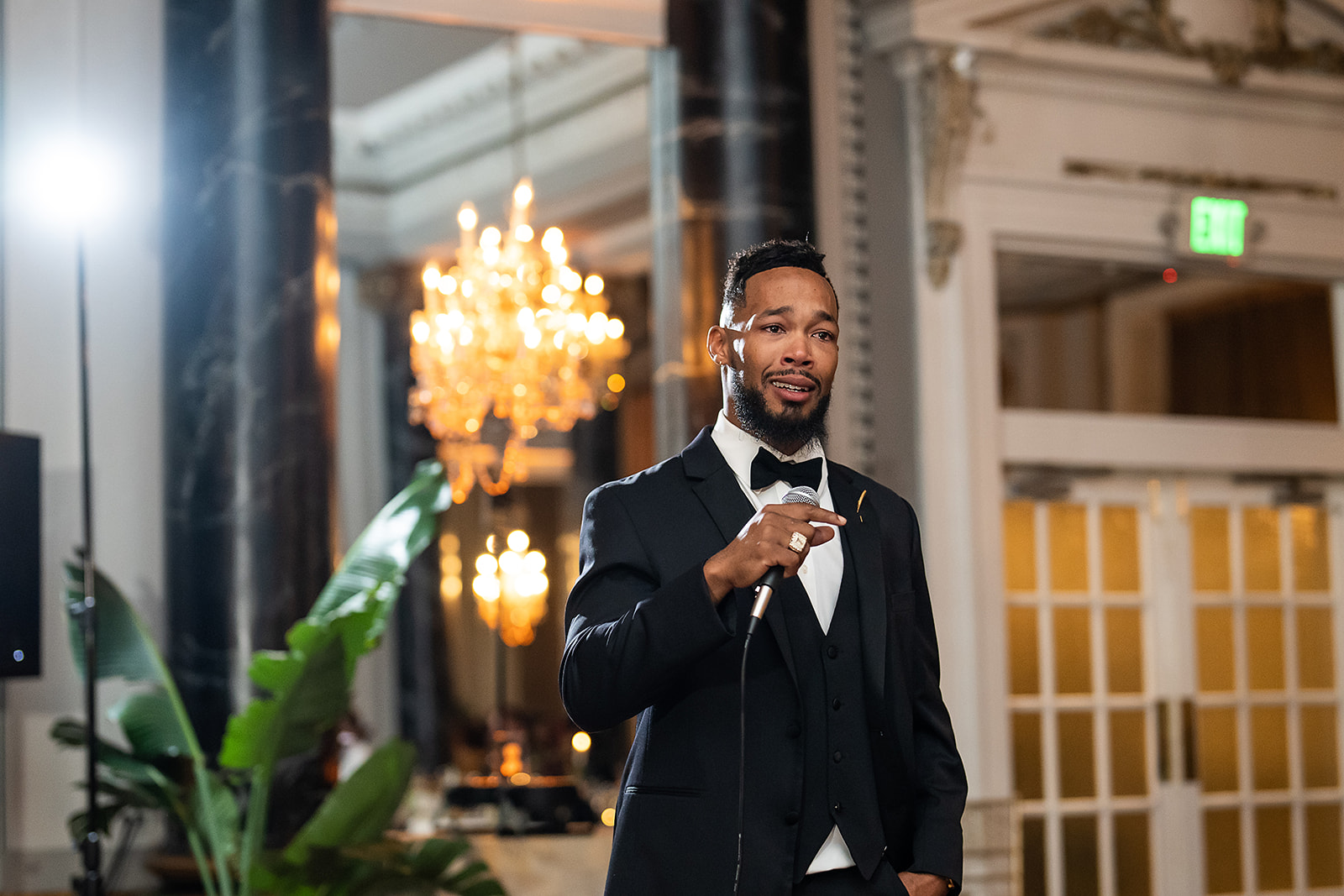 Best man speech with microphone chandelier ballroom tuxedo
