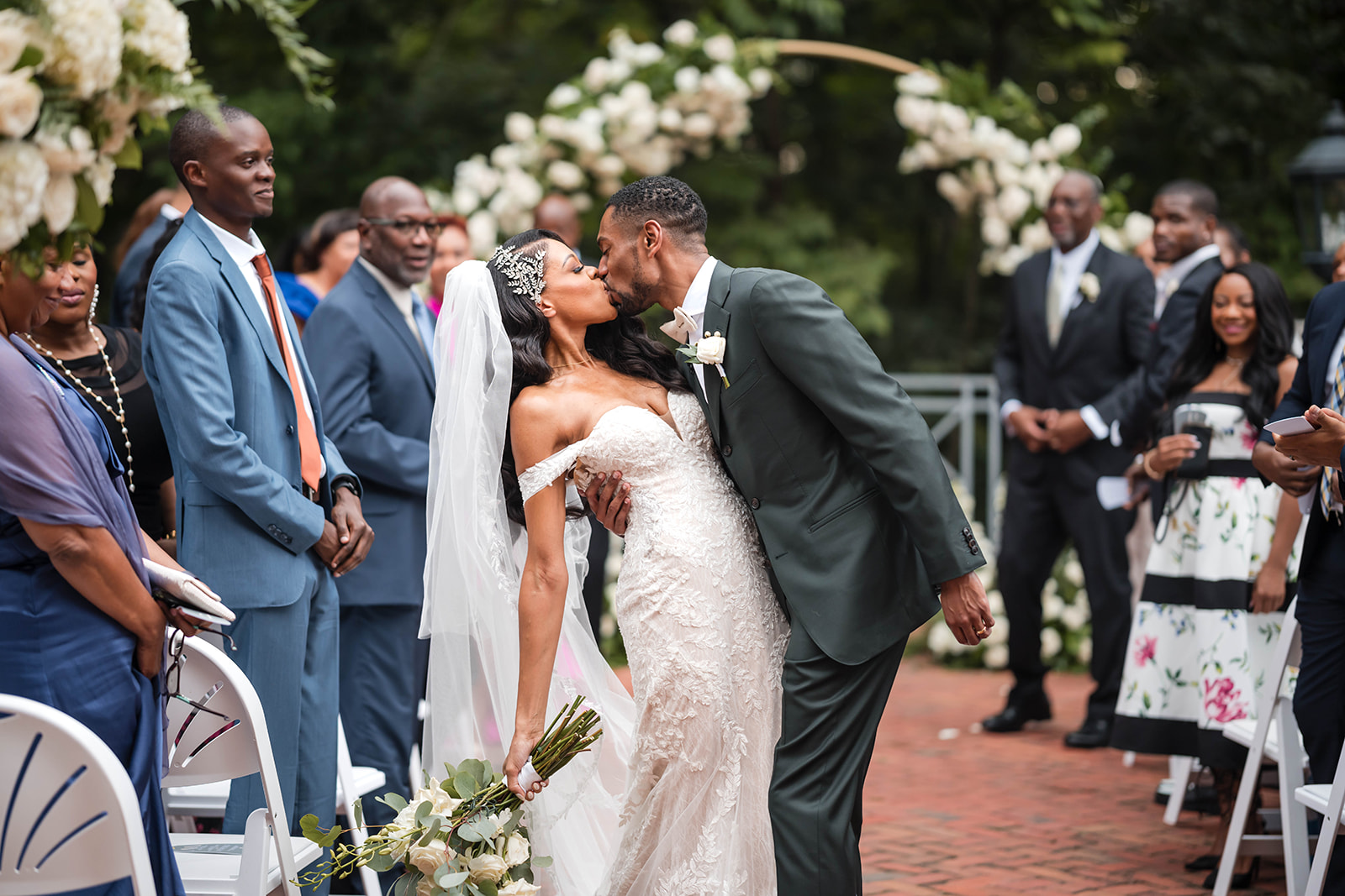 Couple ceremony kiss walking down aisle guests garden wedding