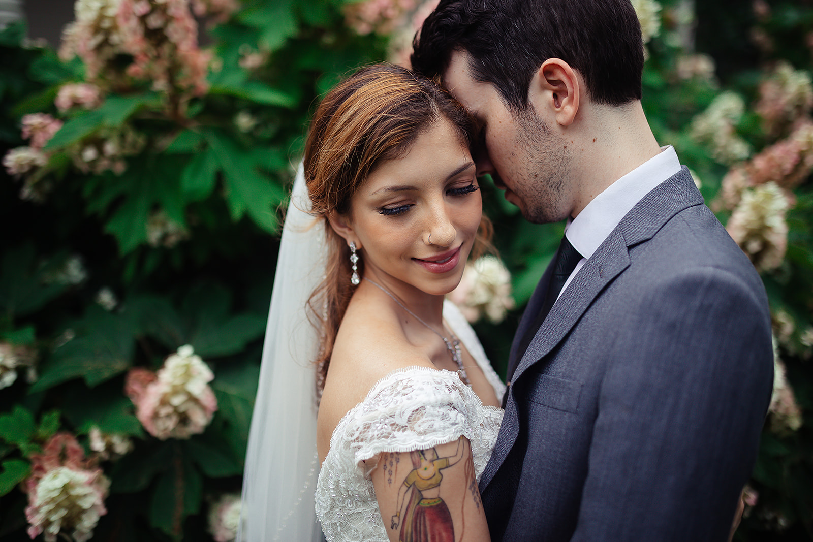 Couple intimate portrait among hydrangea blooms garden