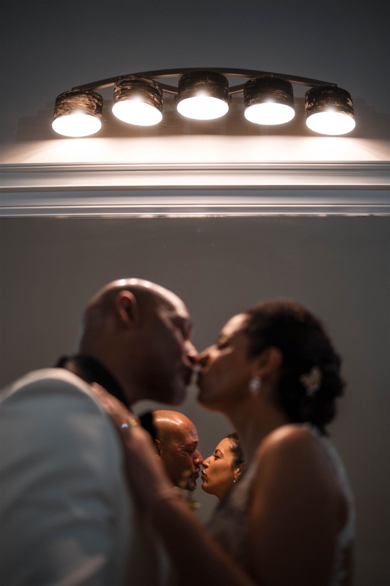 Couple mirror kiss reflection vanity lights intimate portrait