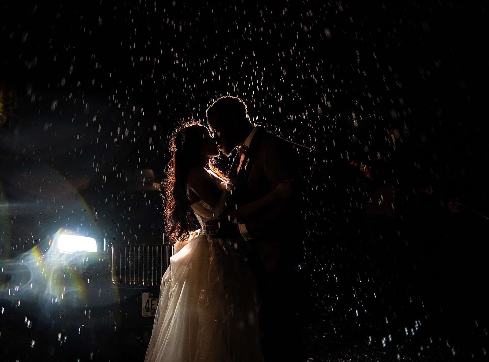 Couple kissing in the rain at night