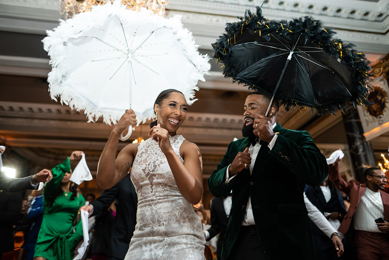 Couple second line with feather parasols in ballroom lace and velvet