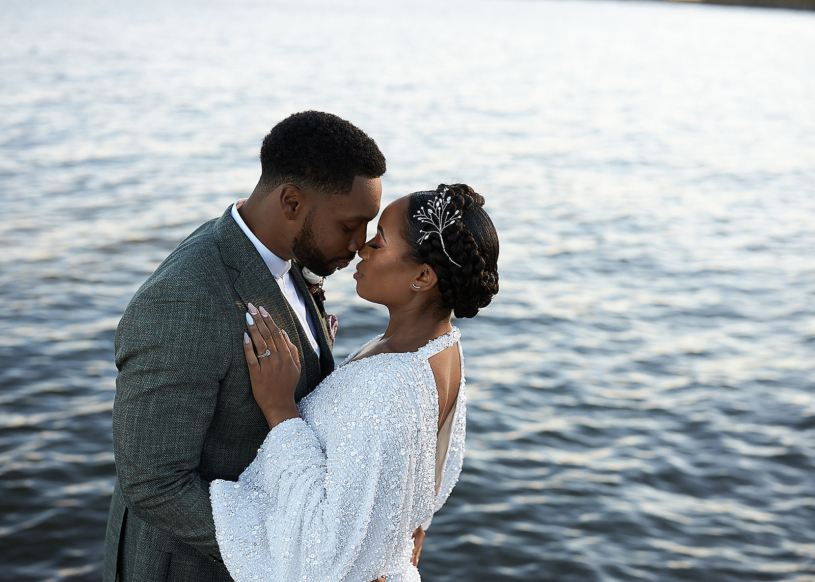 Couple kiss at waterfront during golden hour