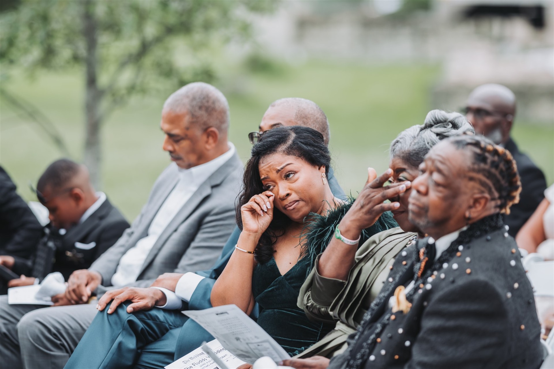 Wedding guests emotional wiping tears during ceremony candid