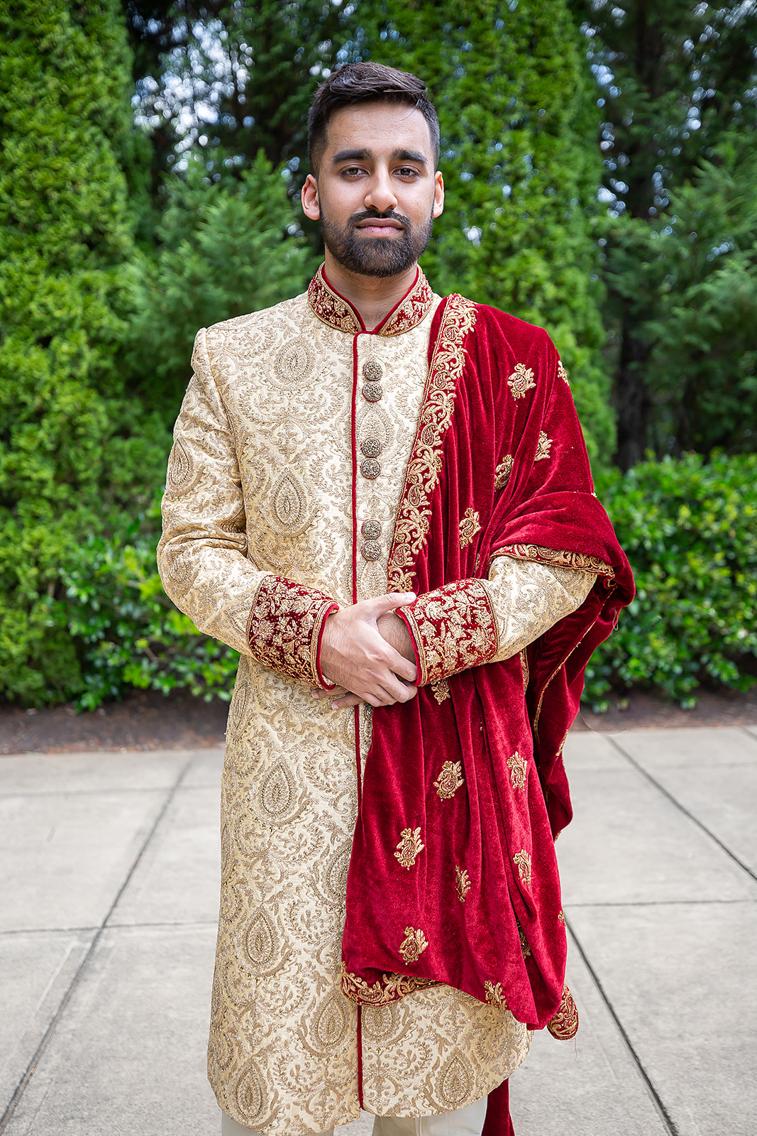 South Asian groom in gold sherwani garden portrait